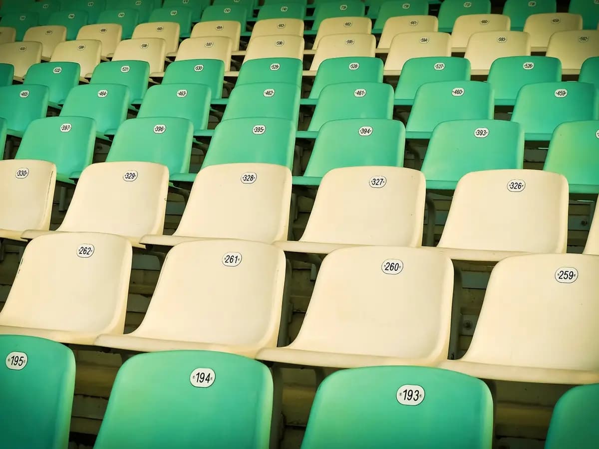 Rows of empty numbered stadium seats in green and white