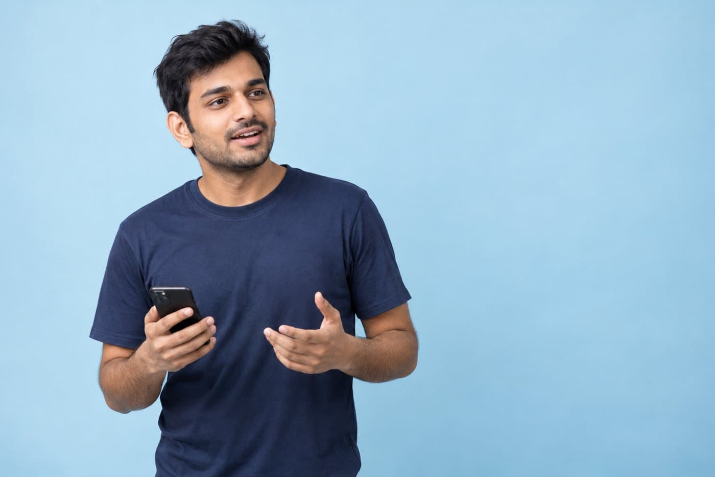 Example seller, a man in a navy T-shirt against a sky-blue backdrop, holding a phone as he talks.