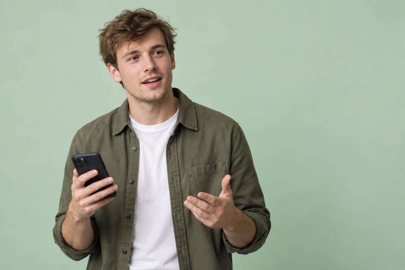Example seller, a man in an olive overshirt against a sage backdrop, holding a phone as he talks.